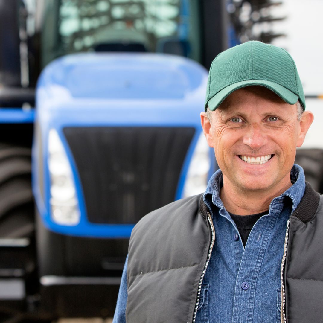 farmer standing in front of a hay baler