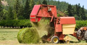 baler rolling a round bale of hay
