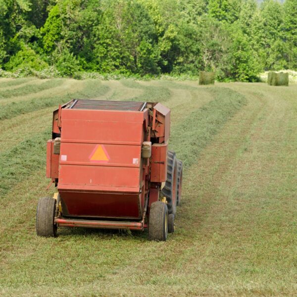 The back of a red baler on a field