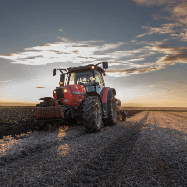 A red tractor barreling hay